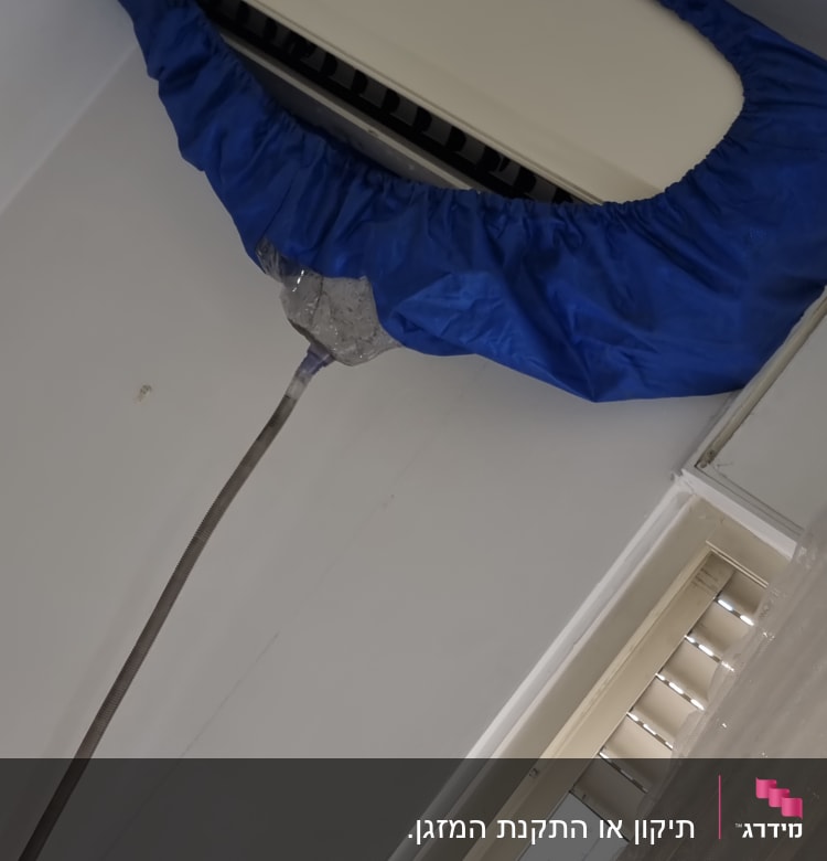 מזגן מכוסה בכיסוי כחול על הקיר